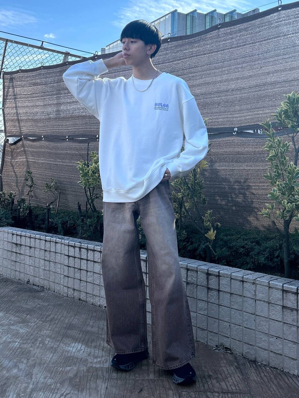 ブラック系のスラックス、ホワイト系のTシャツ/カットソー、ブラウン系のデニムパンツを着用したメンズの冬コーディネートの6枚目の写真