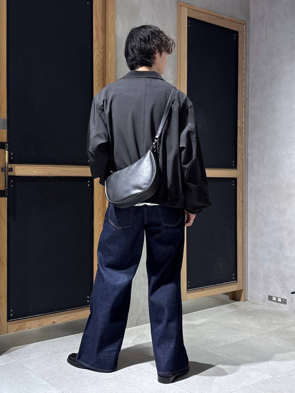 ブラック系のショルダーバッグ、ブラック系のブルゾン、ホワイト系のスウェットを着用したメンズの春コーディネートの9枚目の写真