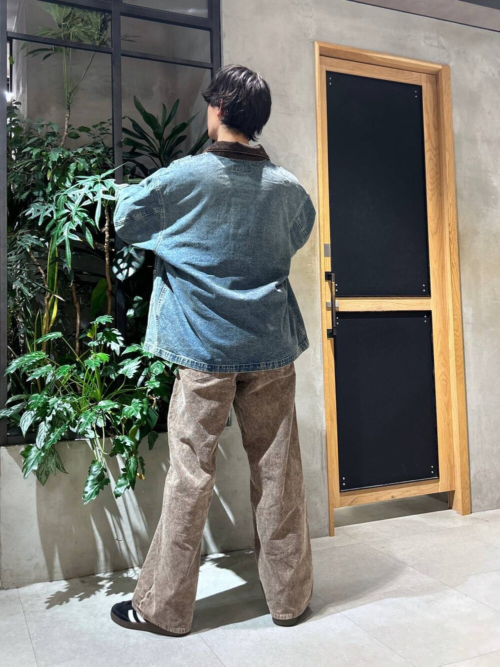 ブラック系のスニーカー、ブルー系のデニムジャケット、ホワイト系のTシャツ/カットソーを着用したメンズの秋コーディネートの5枚目の写真