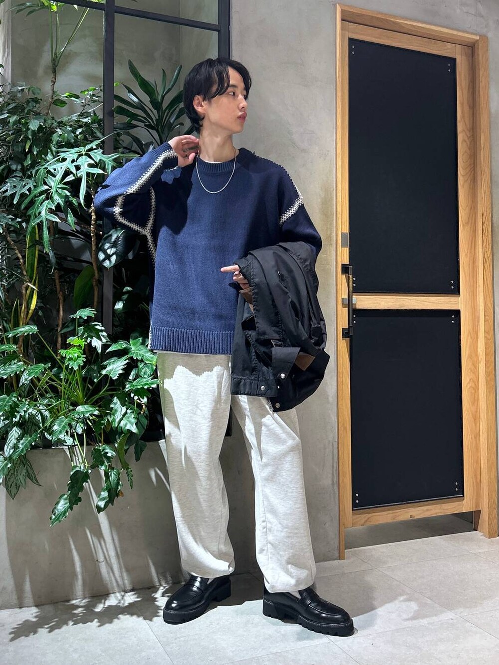 ブラック系のドレスシューズ、ブルー系のニット/セーター、ホワイト系のTシャツ/カットソーを着用したメンズの秋コーディネートの2枚目の写真