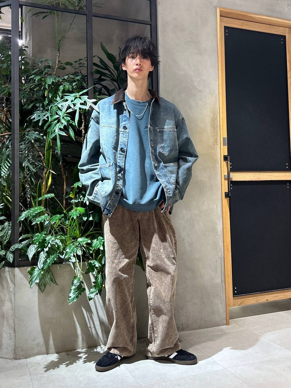 ブラック系のスニーカー、ブルー系のデニムジャケット、ホワイト系のTシャツ/カットソーを着用したメンズの秋コーディネートの3枚目の写真