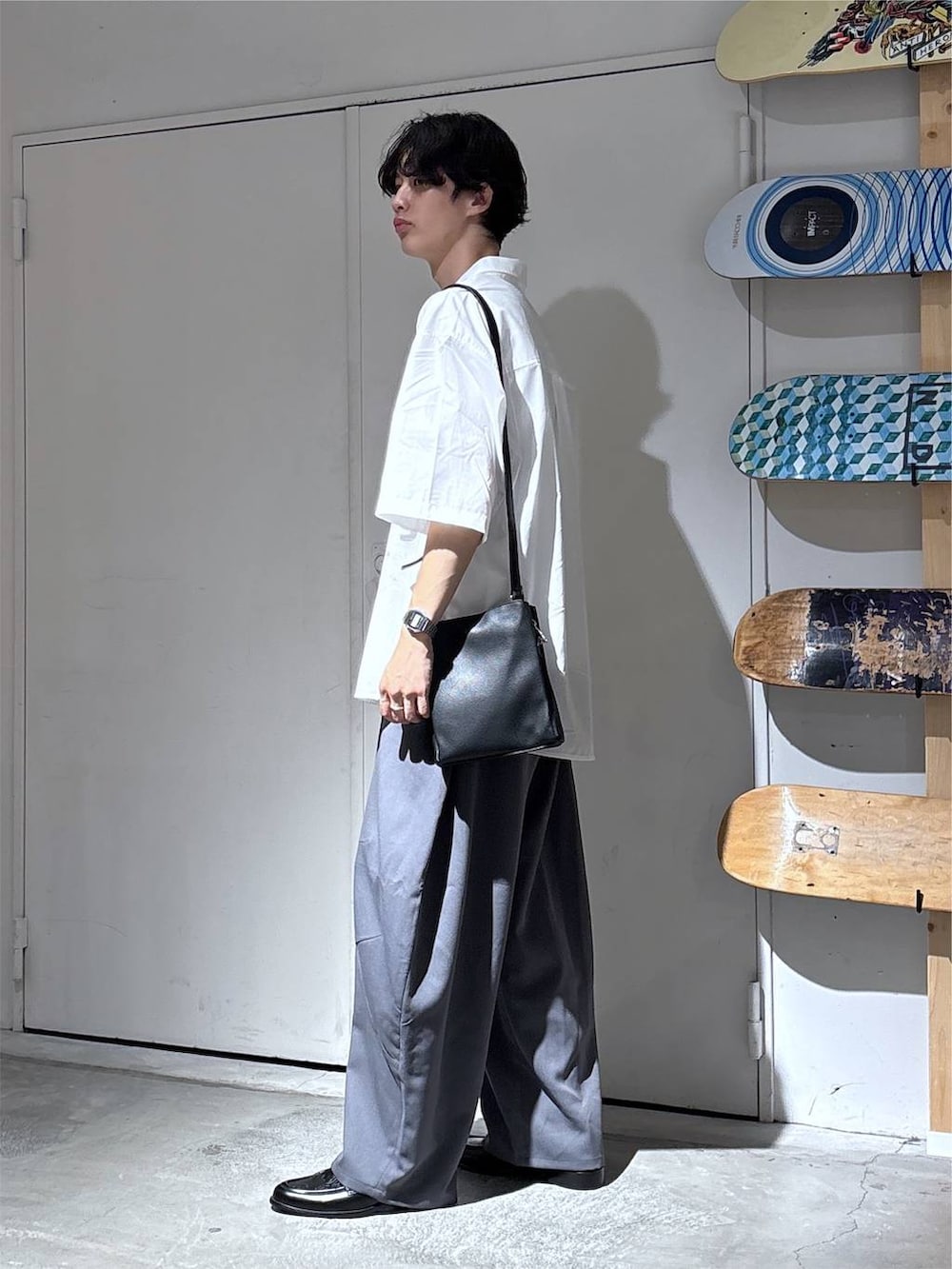 ホワイト系のシャツ/ブラウス、グレー系のスラックス、ブラック系のローファーを着用したメンズの夏コーディネートの4枚目の写真