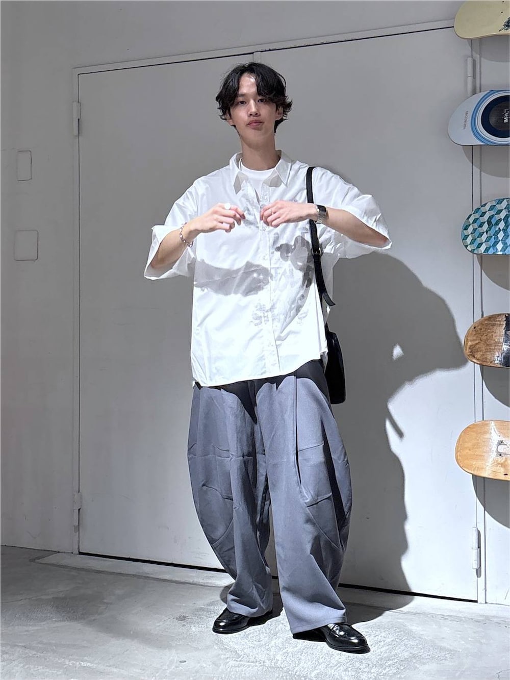 ホワイト系のシャツ/ブラウス、グレー系のスラックス、ブラック系のローファーを着用したメンズの夏コーディネートの3枚目の写真
