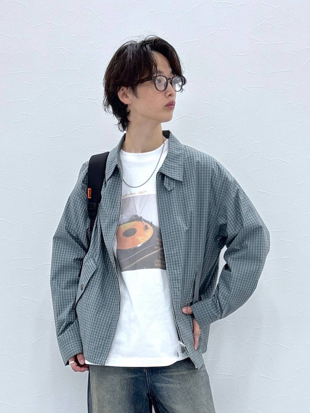 ブラック系のバックパック/リュック、ブルー系のデニムパンツ、ホワイト系のTシャツ/カットソーを着用したメンズの秋コーディネートの2枚目の写真