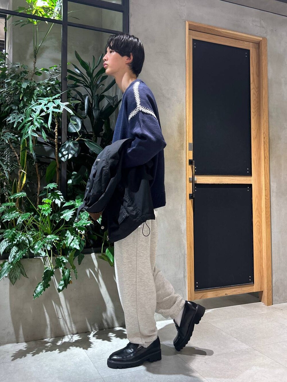 ブラック系のドレスシューズ、ブルー系のニット/セーター、ホワイト系のTシャツ/カットソーを着用したメンズの秋コーディネートの4枚目の写真