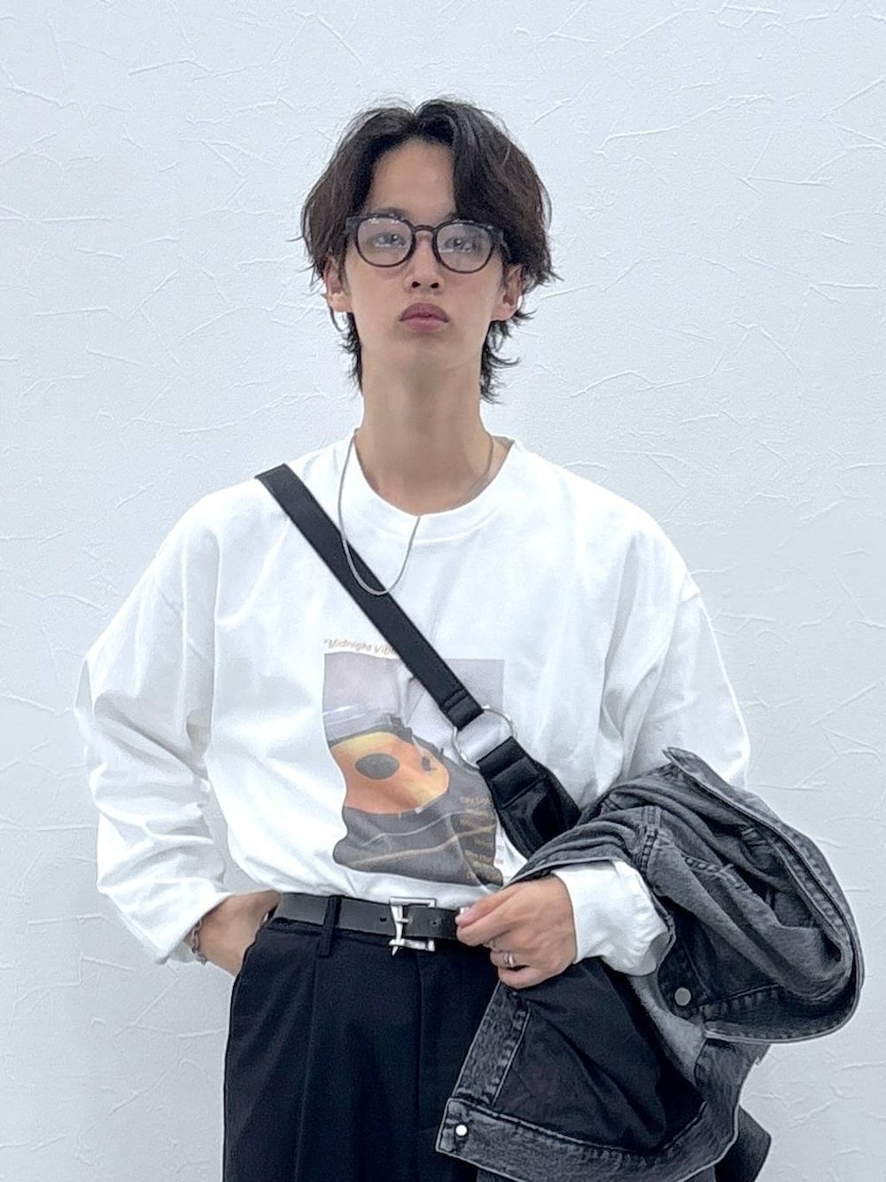 ブラック系のスラックス、グレー系のデニムジャケット、その他のショルダーバッグを着用したメンズの秋コーディネートの2枚目の写真