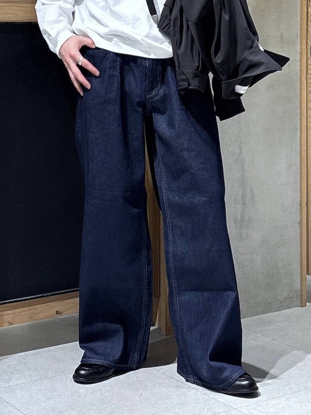 ブラック系のショルダーバッグ、ブラック系のブルゾン、ホワイト系のスウェットを着用したメンズの春コーディネートの3枚目の写真