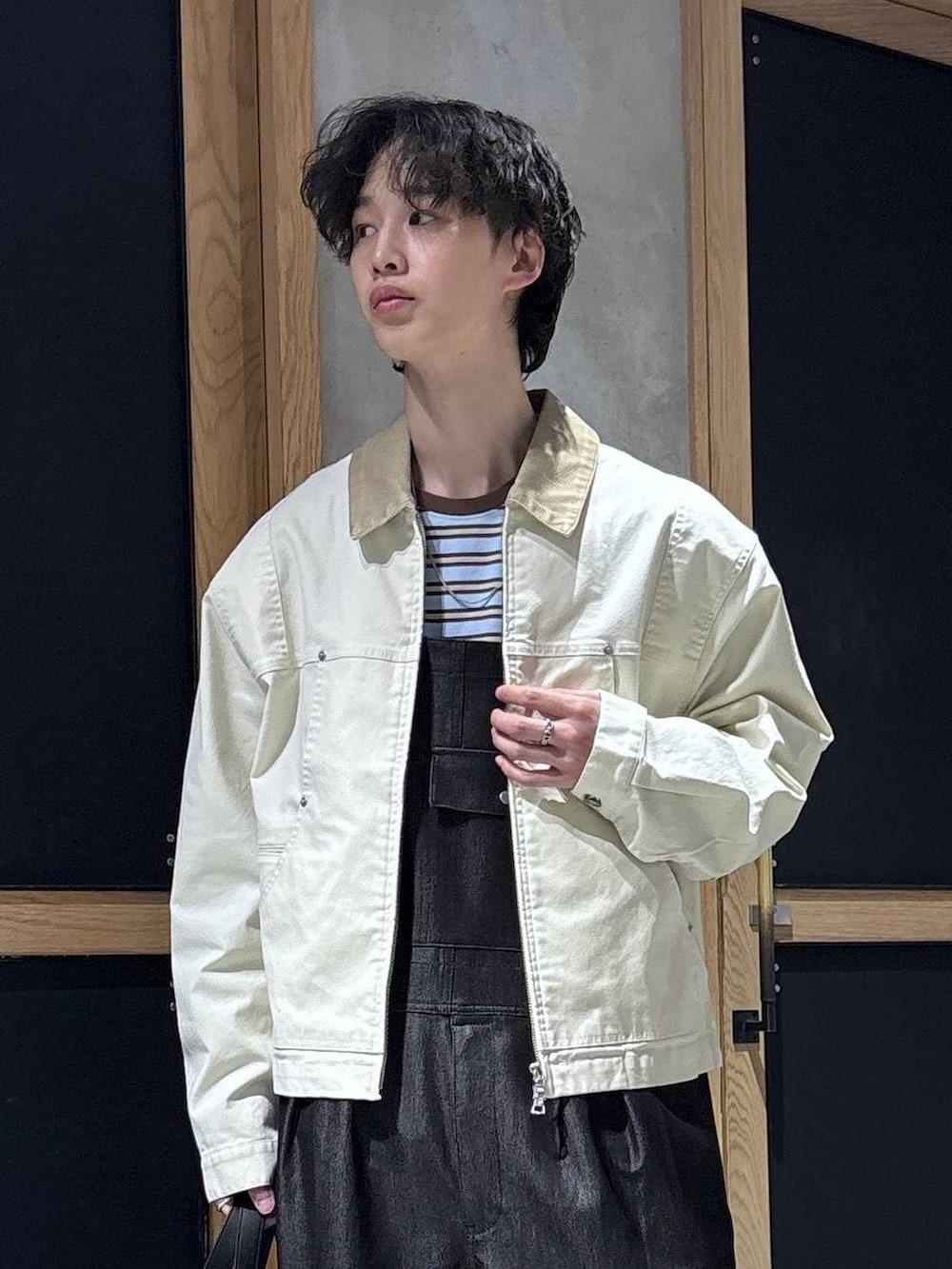 ブラック系のボストンバッグ、ブルー系のTシャツ/カットソー、ホワイト系のブルゾンを着用したメンズの春コーディネートの2枚目の写真