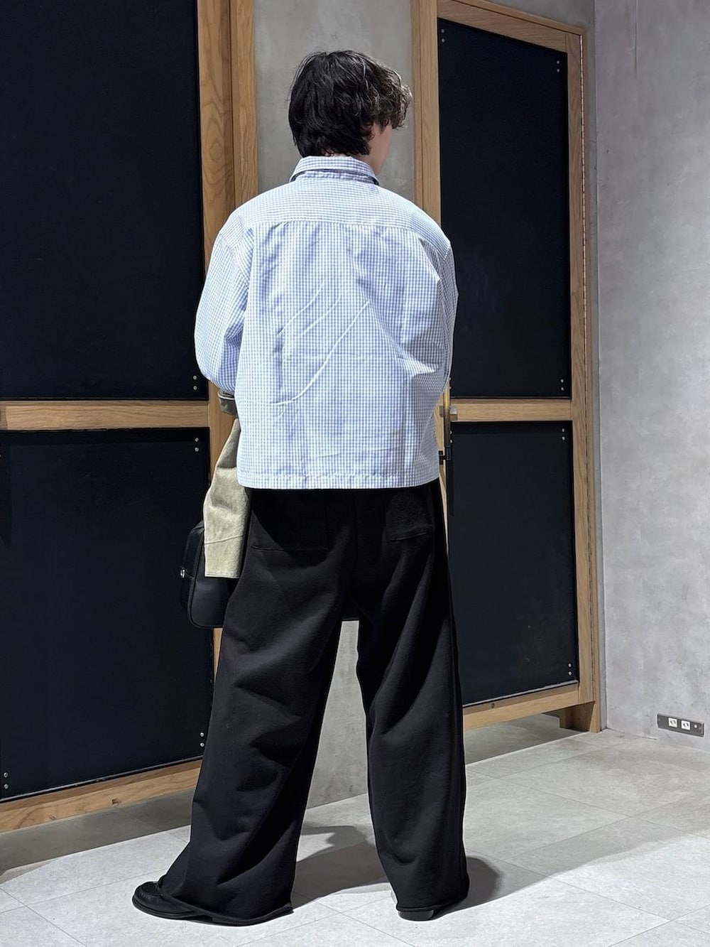 ブラック系のボストンバッグ、ブラック系のローファー、グリーン系のミリタリージャケットを着用したメンズの春コーディネートの5枚目の写真