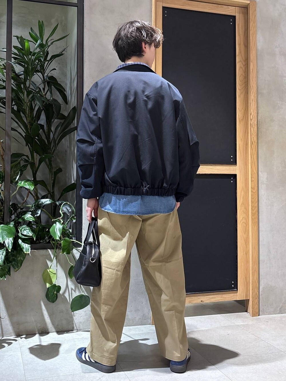 ブラック系のボストンバッグ、ブルー系のシャツ/ブラウス、ブルー系のブルゾンを着用したメンズの冬コーディネートの5枚目の写真