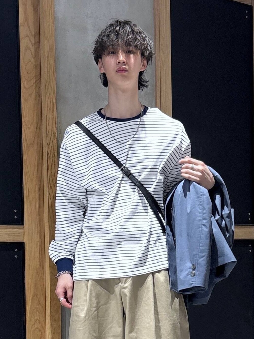 ブルー系のテーラードジャケット、ブラック系のドレスシューズ、ブラック系のショルダーバッグを着用したメンズの春コーディネートの7枚目の写真