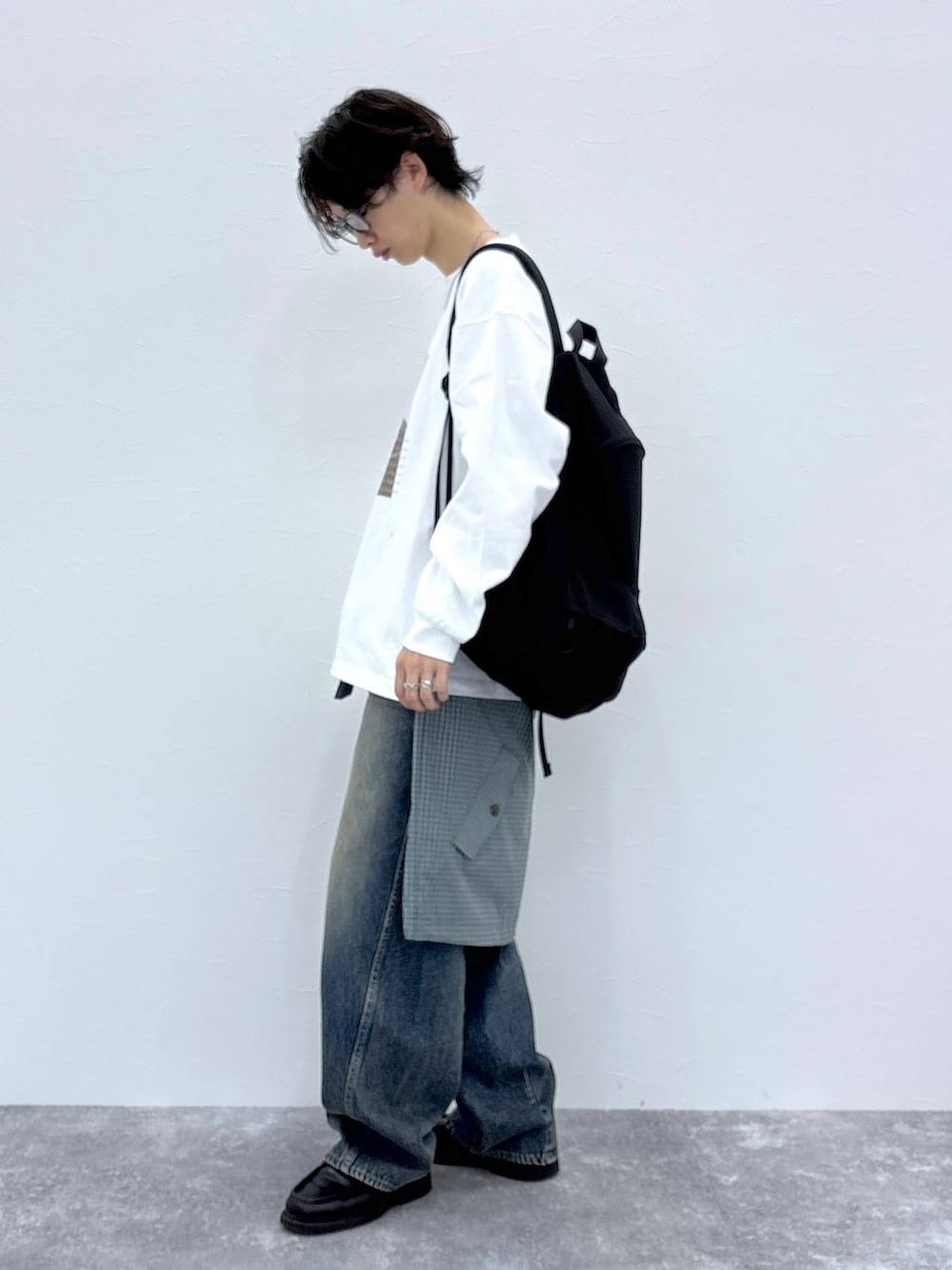 ブラック系のバックパック/リュック、ブルー系のデニムパンツ、ホワイト系のTシャツ/カットソーを着用したメンズの秋コーディネートの8枚目の写真