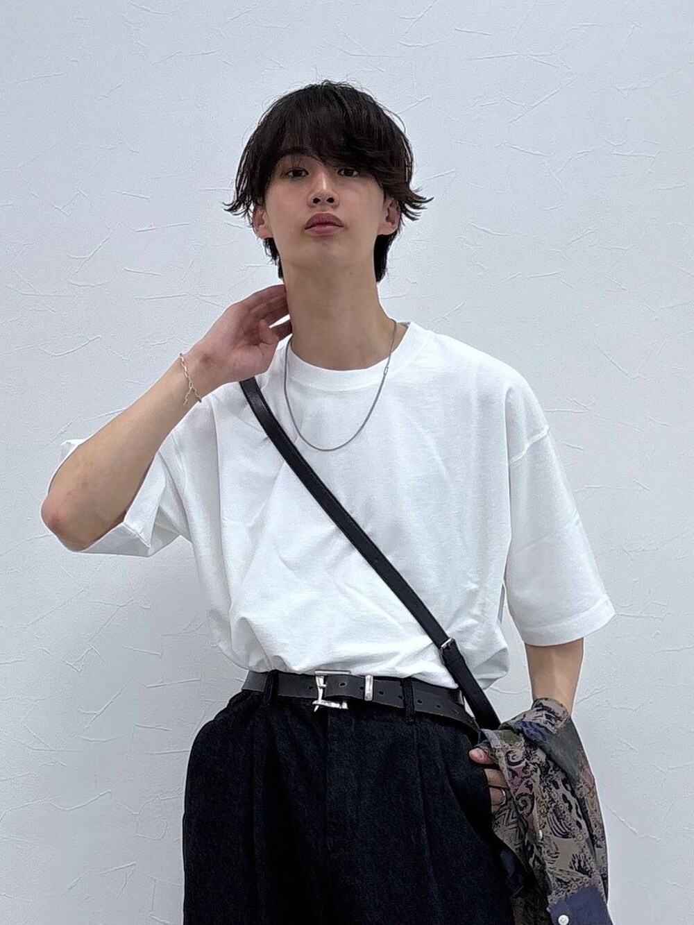 ブラック系のドレスシューズ、ブラック系のデニムパンツ、ホワイト系のTシャツ/カットソーを着用したメンズの春コーディネートの2枚目の写真