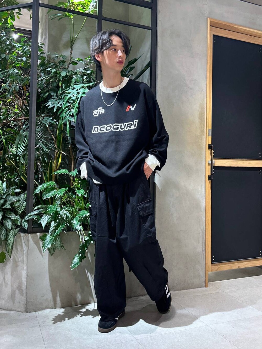 ブラック系のカーゴパンツ、ブラック系のスニーカー、ホワイト系のTシャツ/カットソーを着用したメンズの秋コーディネートの2枚目の写真