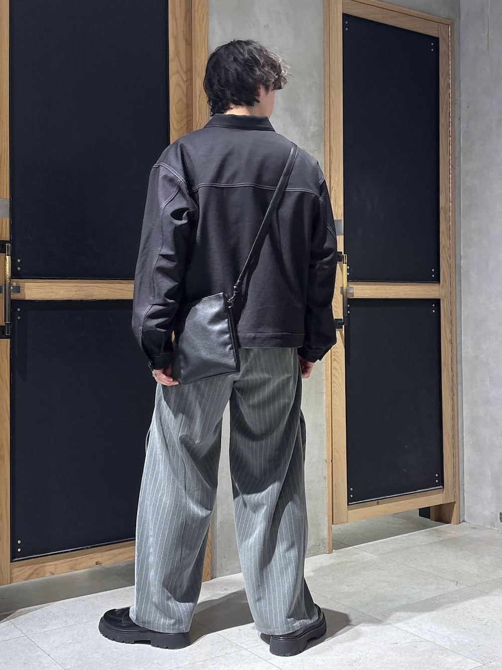 ブラック系のショルダーバッグ、ブラック系のドレスシューズ、ブラック系のブルゾンを着用したメンズの春コーディネートの5枚目の写真