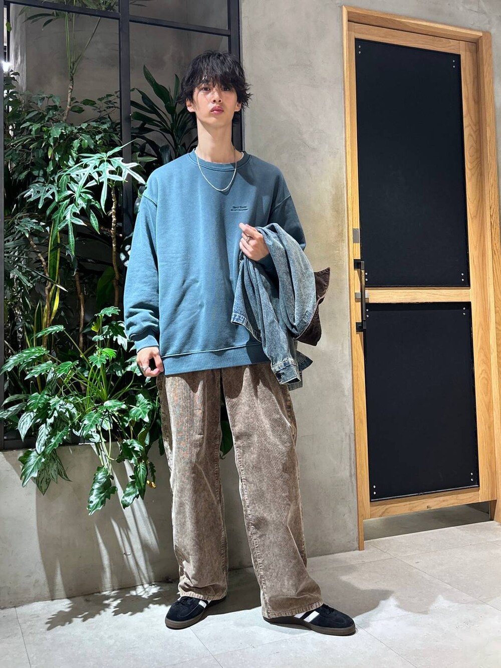 ブラック系のスニーカー、ブルー系のデニムジャケット、ホワイト系のTシャツ/カットソーを着用したメンズの秋コーディネートの6枚目の写真