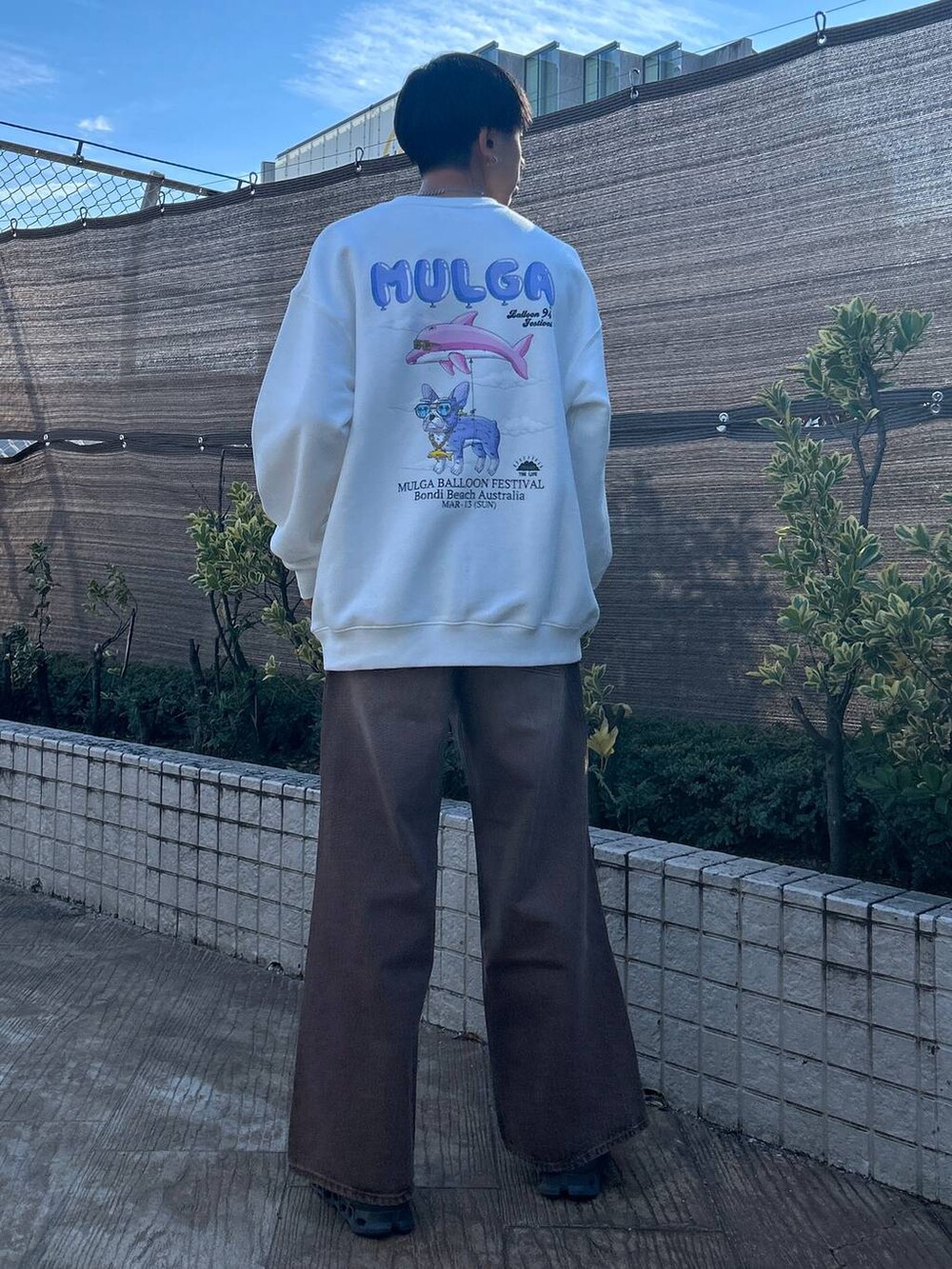 ブラック系のスラックス、ホワイト系のTシャツ/カットソー、ブラウン系のデニムパンツを着用したメンズの冬コーディネートの5枚目の写真