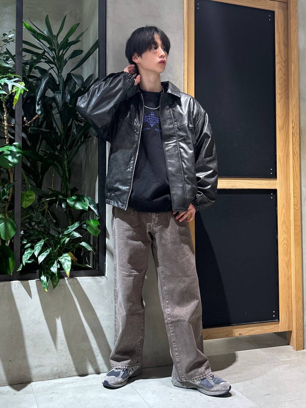 ブラウン系のデニムパンツ、ブラック系のスウェット、ブラック系のブルゾンを着用したメンズの冬コーディネートの4枚目の写真