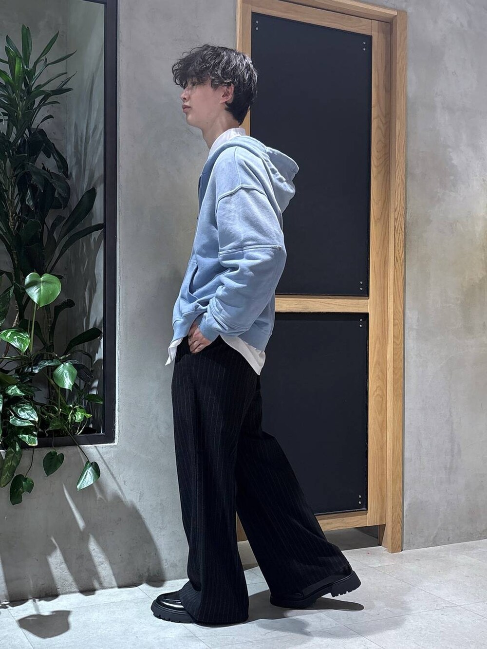 ブラック系のスラックス、ブラック系のドレスシューズ、ブルー系のパーカーを着用したメンズの冬コーディネートの4枚目の写真