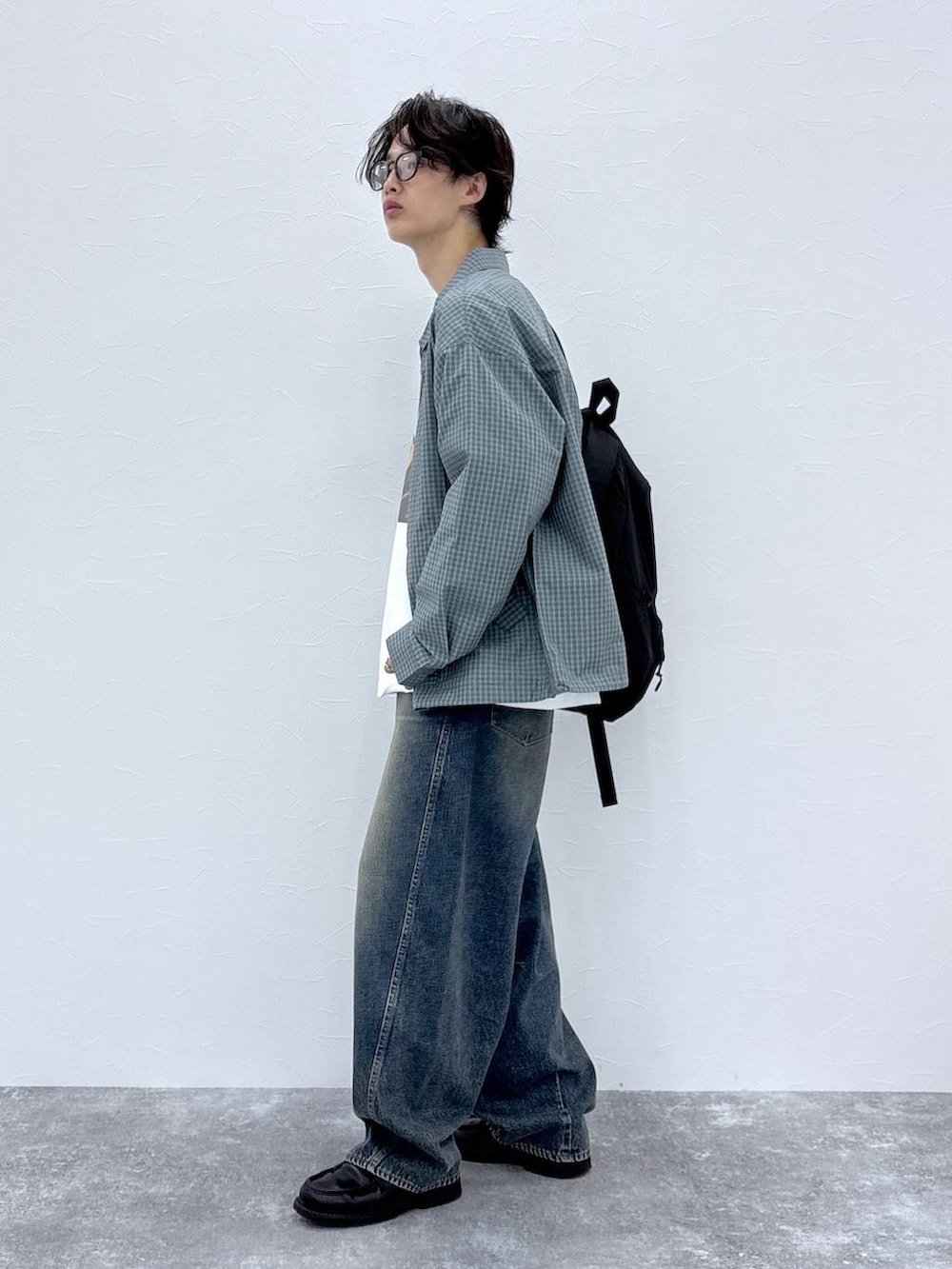 ブラック系のバックパック/リュック、ブルー系のデニムパンツ、ホワイト系のTシャツ/カットソーを着用したメンズの秋コーディネートの4枚目の写真