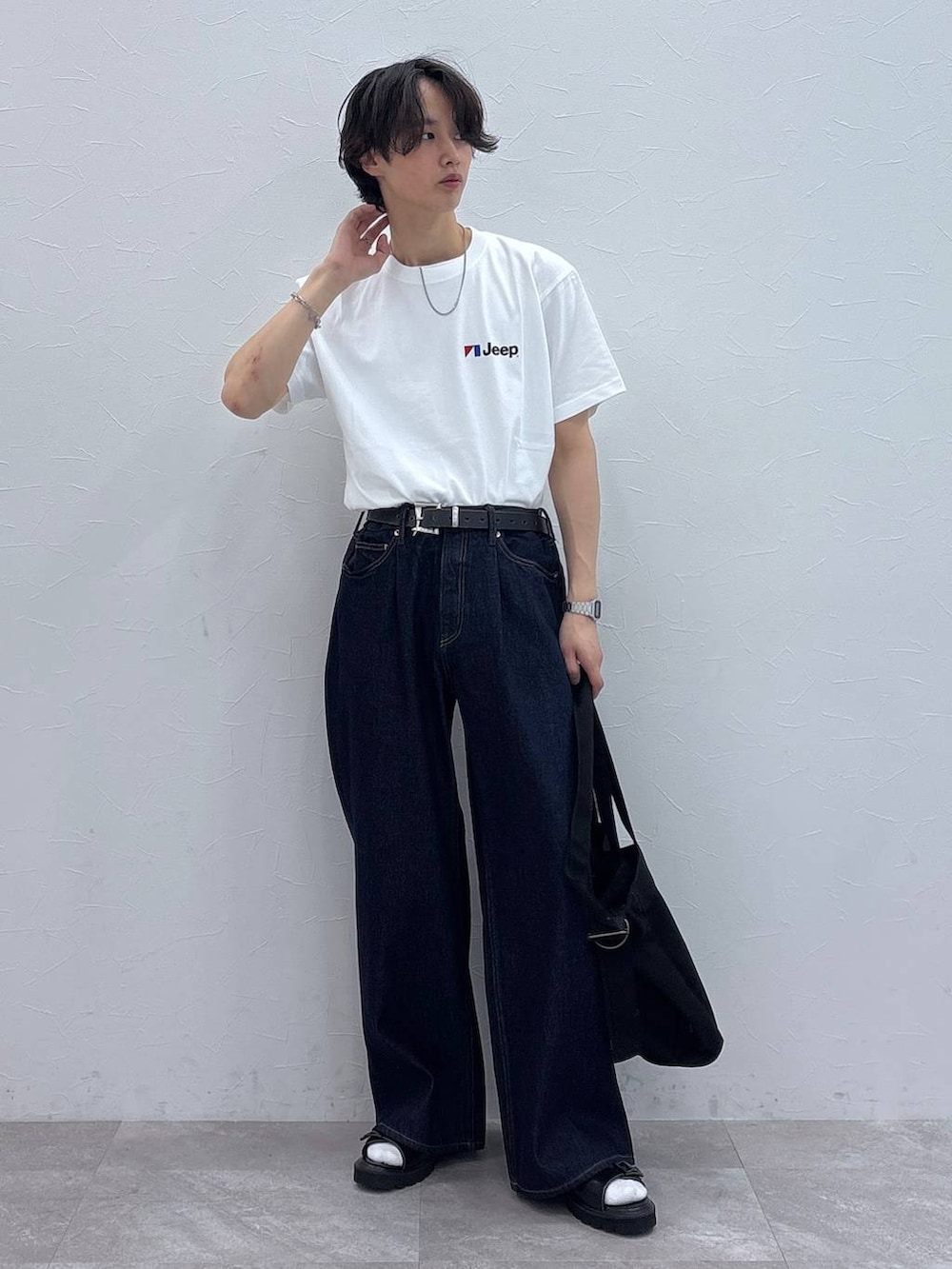 ブラック系のサンダル、ブルー系のデニムパンツ、ブラック系のショルダーバッグを着用したメンズの夏コーディネートの4枚目の写真