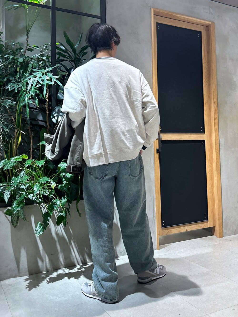 グレー系のスニーカー、ブルー系のデニムパンツ、グリーン系のブルゾンを着用したメンズの秋コーディネートの8枚目の写真