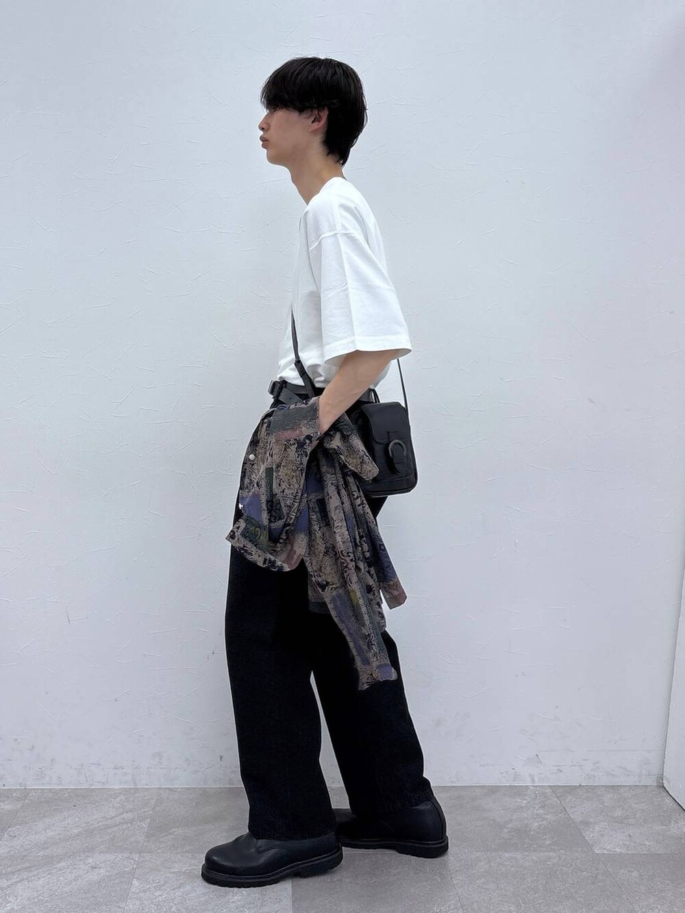 ブラック系のドレスシューズ、ブラック系のデニムパンツ、ホワイト系のTシャツ/カットソーを着用したメンズの春コーディネートの4枚目の写真