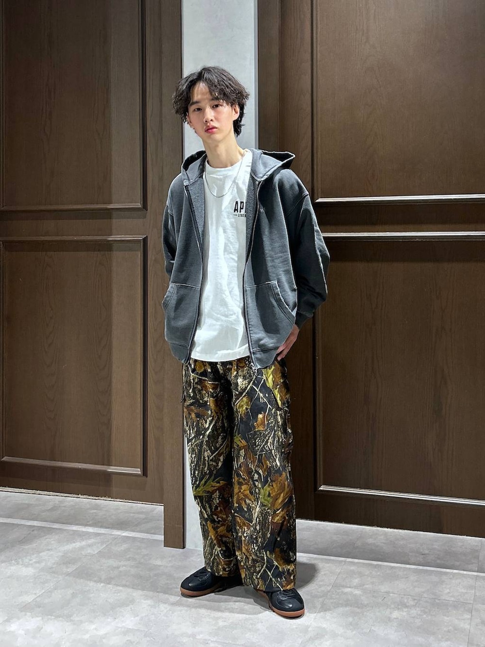 ブラック系のパーカー、ホワイト系のTシャツ/カットソー、ブラック系のスニーカーを着用したメンズの春コーディネートの2枚目の写真