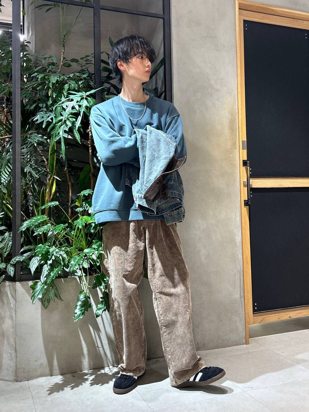 ブラック系のスニーカー、ブルー系のデニムジャケット、ホワイト系のTシャツ/カットソーを着用したメンズの秋コーディネートの7枚目の写真