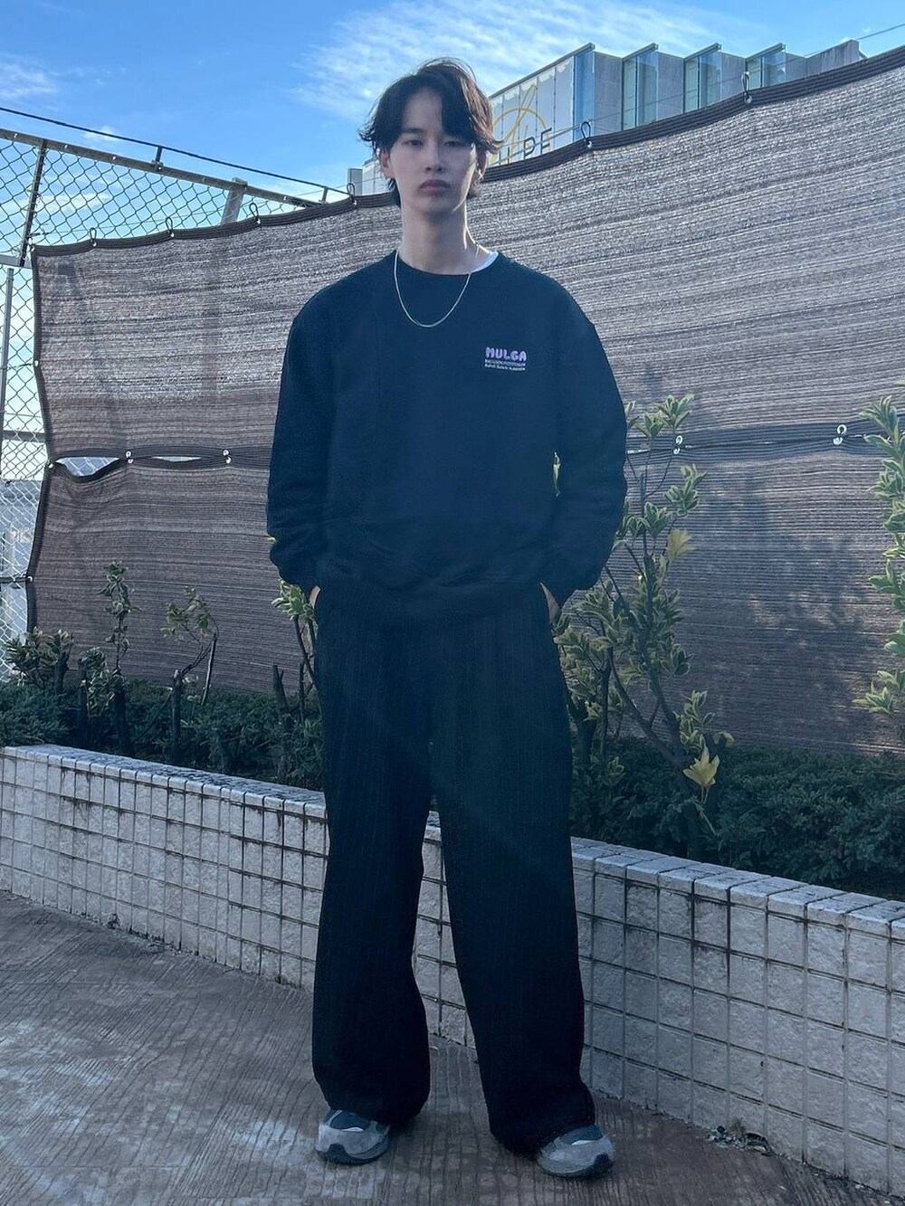 ブラック系のスラックス、ホワイト系のTシャツ/カットソー、ブラウン系のデニムパンツを着用したメンズの冬コーディネートの4枚目の写真