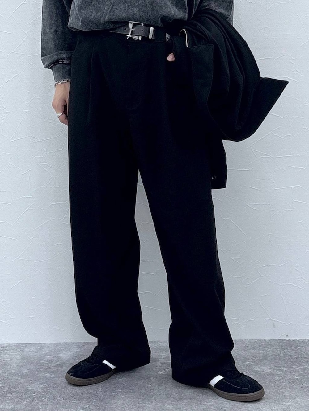 ブラック系のスニーカー、グレー系のTシャツ/カットソー、ブラック系のブルゾンを着用したメンズの秋コーディネートの3枚目の写真