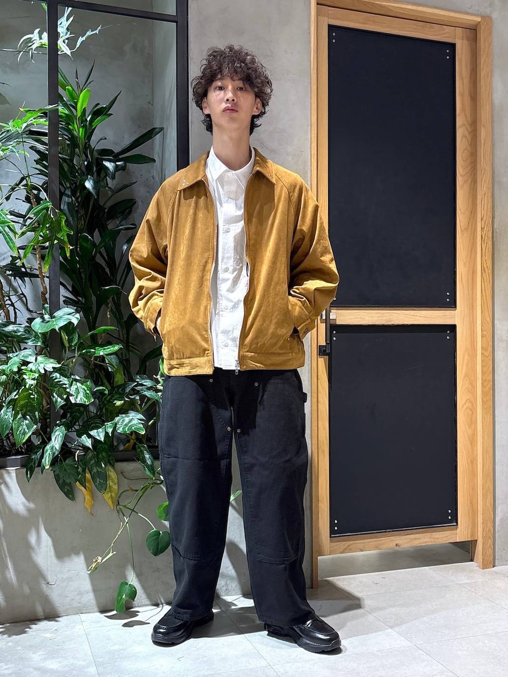 ブラック系のローファー、ブラック系のチノパンツ、ブラウン系のブルゾンを着用したメンズの秋コーディネートの5枚目の写真