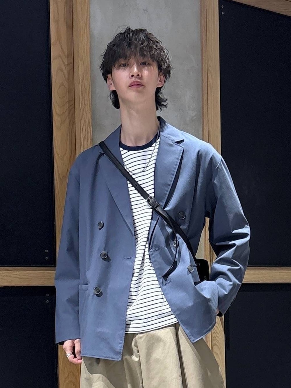 ブルー系のテーラードジャケット、ブラック系のドレスシューズ、ブラック系のショルダーバッグを着用したメンズの春コーディネートの2枚目の写真