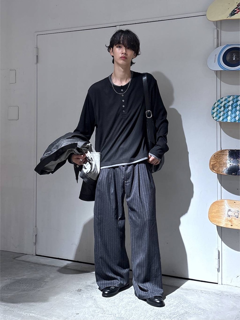 ブラック系のショルダーバッグ、ブラック系のデニムジャケット、グレー系のスラックスを着用したメンズの秋コーディネートの6枚目の写真