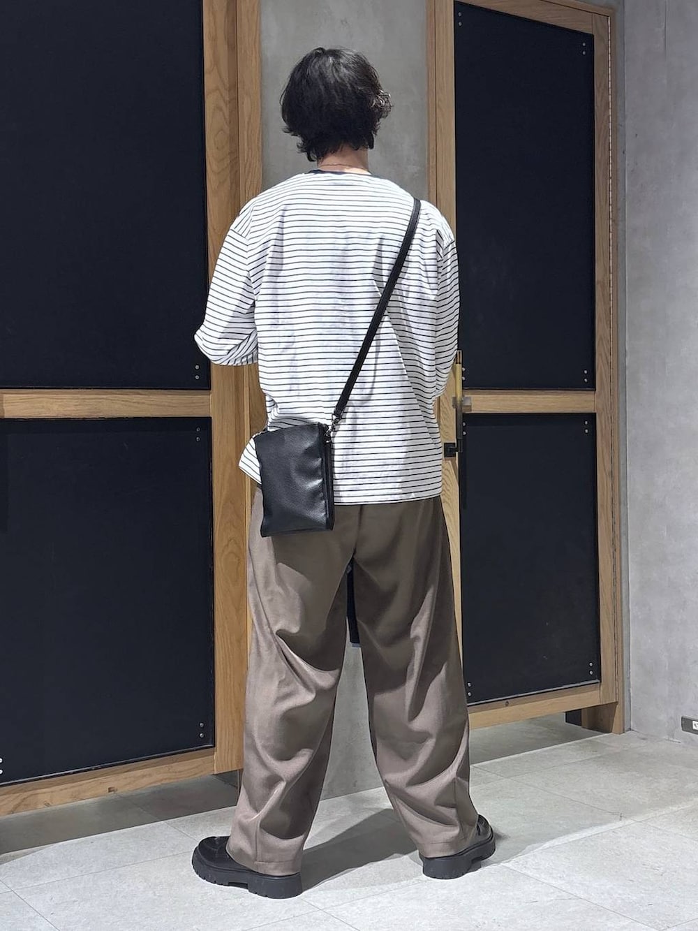 ブラック系のショルダーバッグ、ブラック系のドレスシューズ、ホワイト系のTシャツ/カットソーを着用したメンズの春コーディネートの9枚目の写真