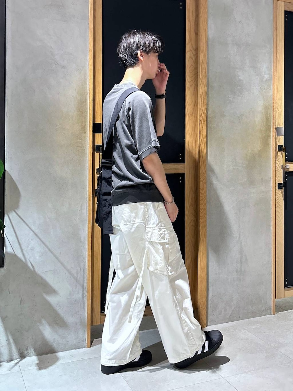 ホワイト系のカーゴパンツ、グレー系のTシャツ/カットソー、ブラック系のショルダーバッグを着用したメンズの秋コーディネートの4枚目の写真