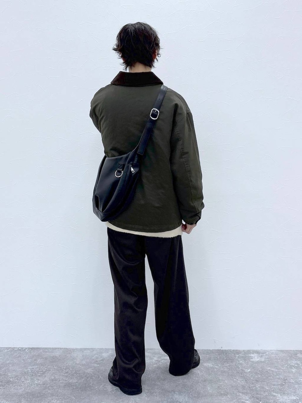 ホワイト系のカーディガン/ボレロ、ブラウン系のスラックス、グリーン系のブルゾンを着用したメンズの秋コーディネートの5枚目の写真