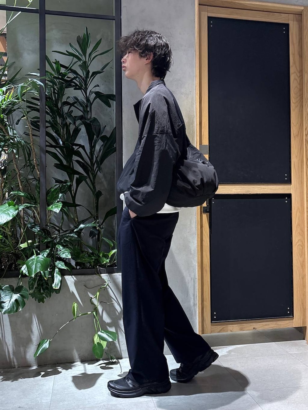 ブラック系のスニーカー、ブルー系のスラックス、ブラック系のショルダーバッグを着用したメンズの春コーディネートの8枚目の写真