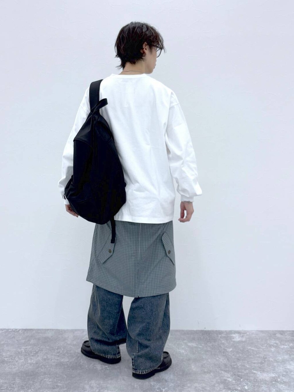 ブラック系のバックパック/リュック、ブルー系のデニムパンツ、ホワイト系のTシャツ/カットソーを着用したメンズの秋コーディネートの9枚目の写真