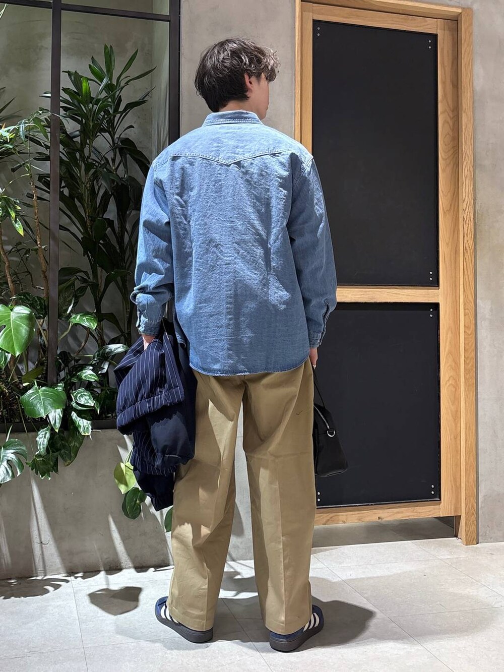 ブラック系のボストンバッグ、ブルー系のシャツ/ブラウス、ブルー系のブルゾンを着用したメンズの冬コーディネートの9枚目の写真