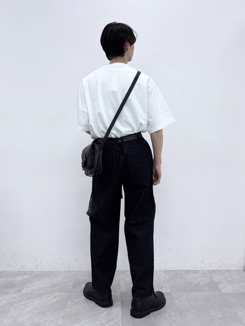 ブラック系のドレスシューズ、ブラック系のデニムパンツ、ホワイト系のTシャツ/カットソーを着用したメンズの春コーディネートの5枚目の写真