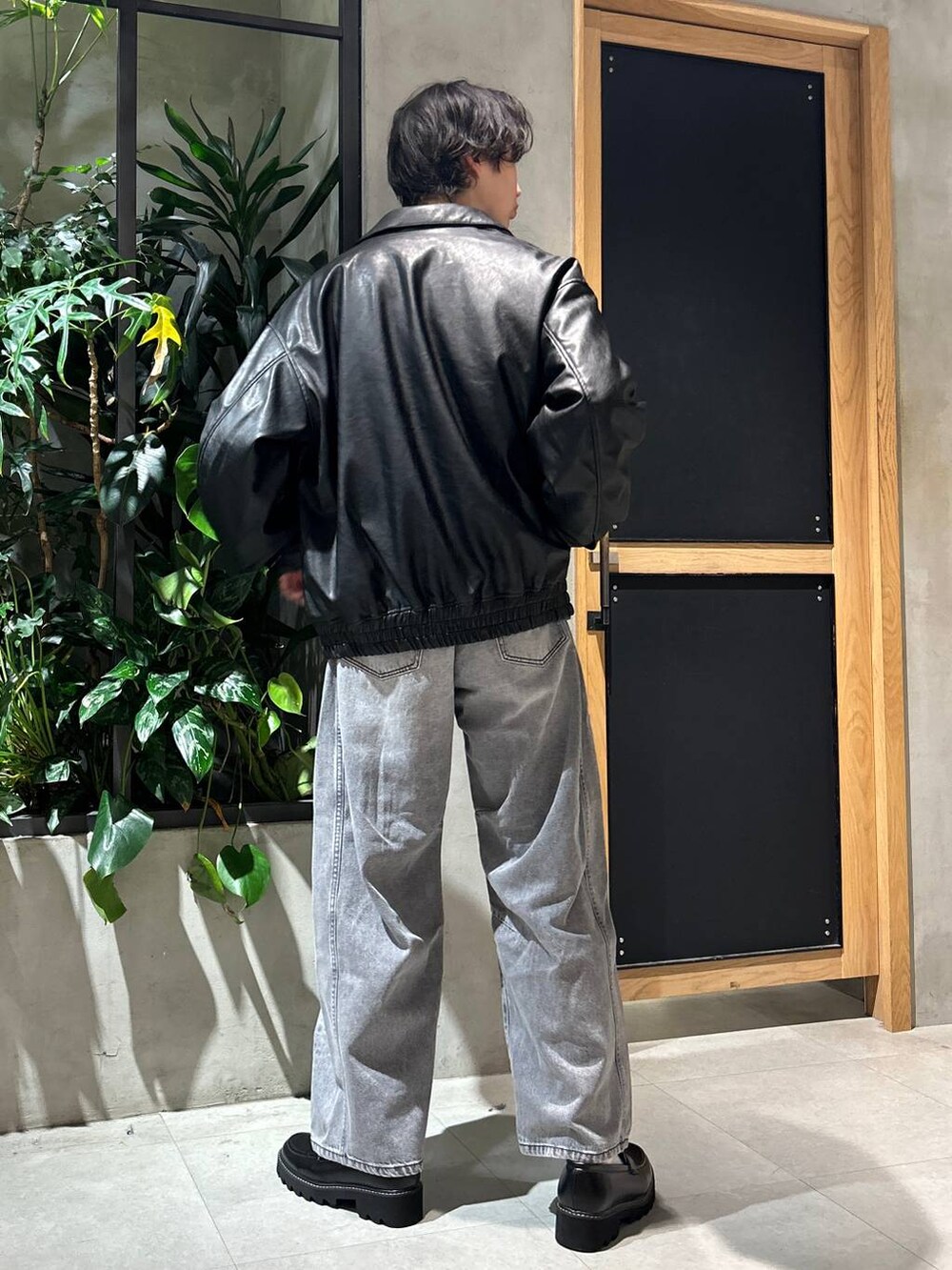 グレー系のブルゾン、ブラック系のドレスシューズ、グレー系のデニムパンツを着用したメンズの冬コーディネートの5枚目の写真