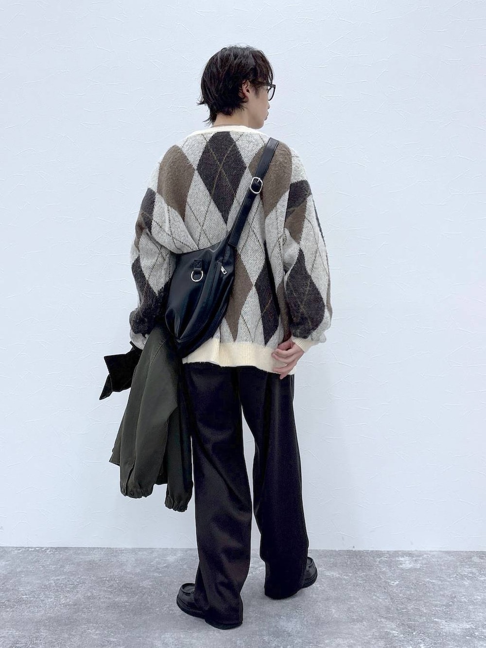 ホワイト系のカーディガン/ボレロ、ブラウン系のスラックス、グリーン系のブルゾンを着用したメンズの秋コーディネートの9枚目の写真