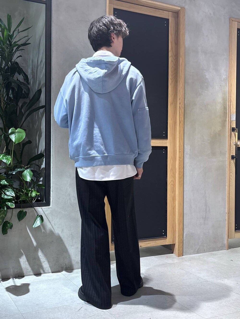 ブラック系のスラックス、ブラック系のドレスシューズ、ブルー系のパーカーを着用したメンズの冬コーディネートの5枚目の写真