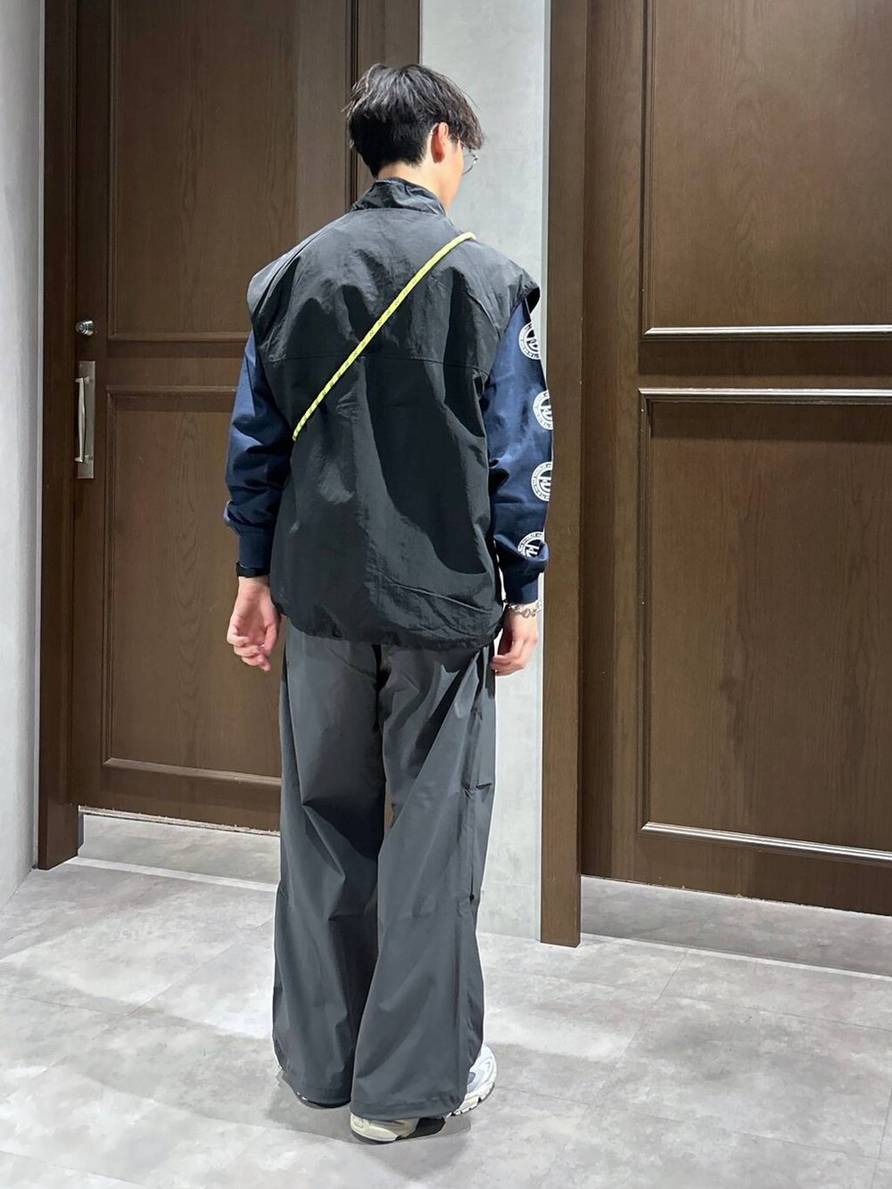 ブラック系のベスト、ブルー系のTシャツ/カットソー、グレー系のスウェットパンツを着用したメンズの春コーディネートの4枚目の写真