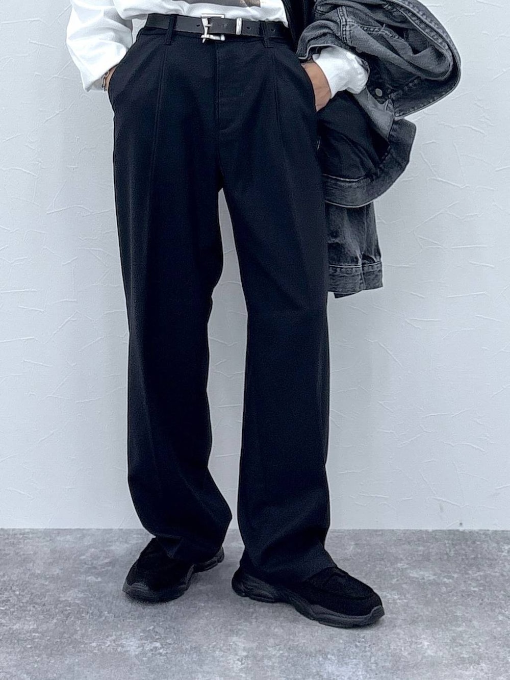 ブラック系のスラックス、グレー系のデニムジャケット、その他のショルダーバッグを着用したメンズの秋コーディネートの3枚目の写真