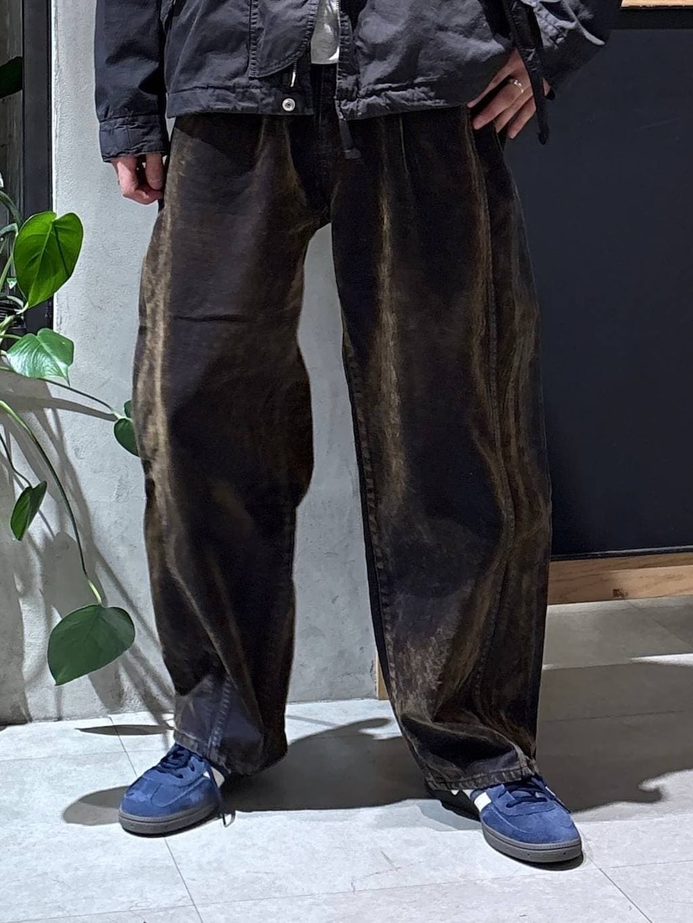 ブラック系のショルダーバッグ、ブラック系のモッズコート、ブルー系のスニーカーを着用したメンズの春コーディネートの3枚目の写真