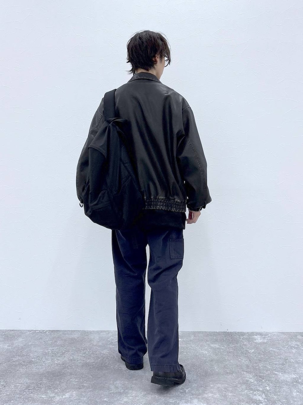 ブラック系のスウェット、ブラック系のブルゾン、ブラック系のバックパック/リュックを着用したメンズの秋コーディネートの9枚目の写真