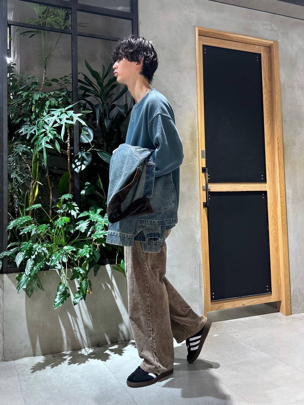 ブラック系のスニーカー、ブルー系のデニムジャケット、ホワイト系のTシャツ/カットソーを着用したメンズの秋コーディネートの8枚目の写真