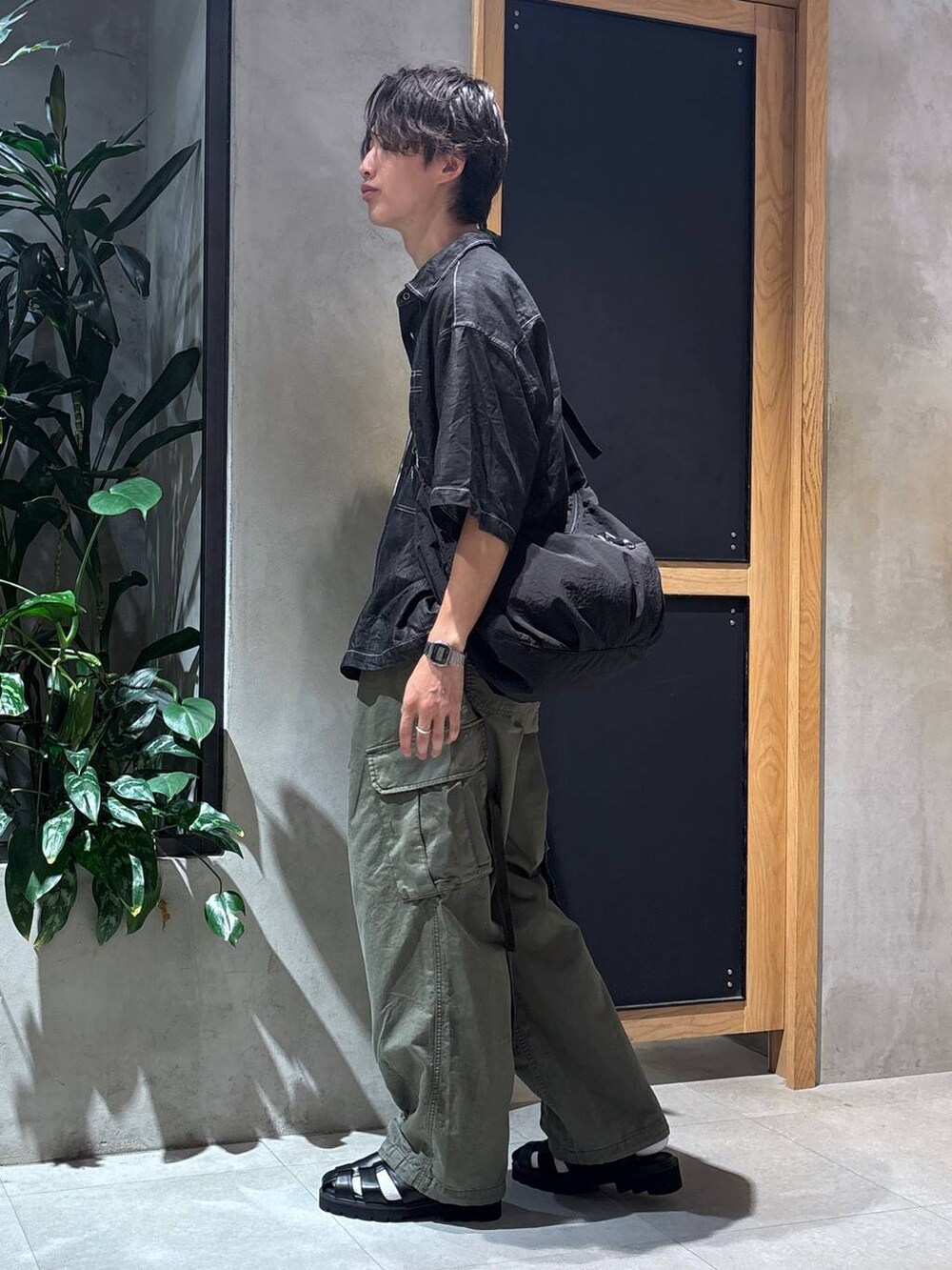 グリーン系のカーゴパンツ、ブラック系のサンダル、ブラック系のシャツ/ブラウスを着用したメンズの夏コーディネートの8枚目の写真